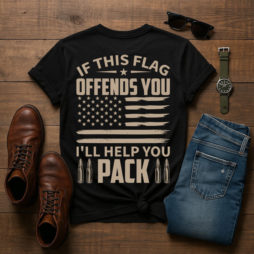 Black t-shirt with text and American flag design on a wooden surface with shoes, jeans, and accessories.