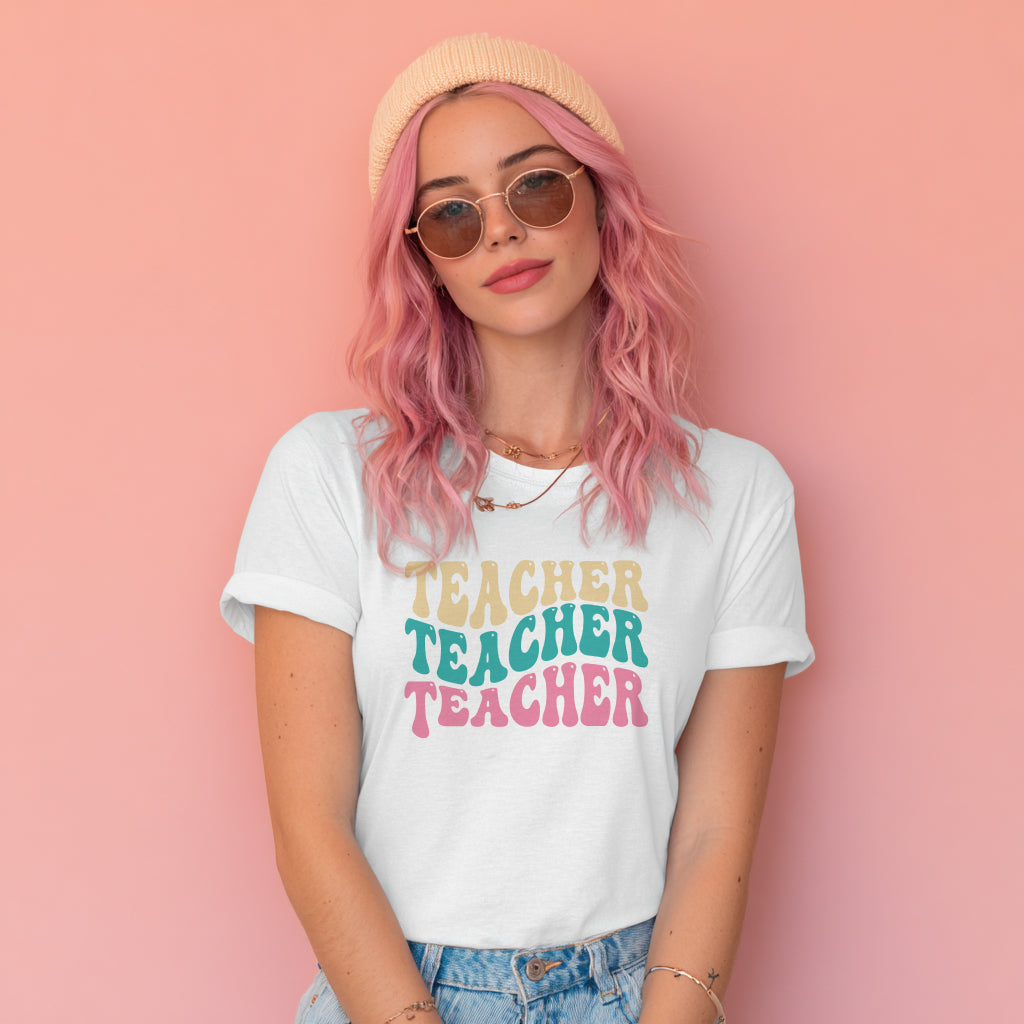 Person wearing a white t-shirt with 'TEACHER TEACHER TEACHER' text on a pink background