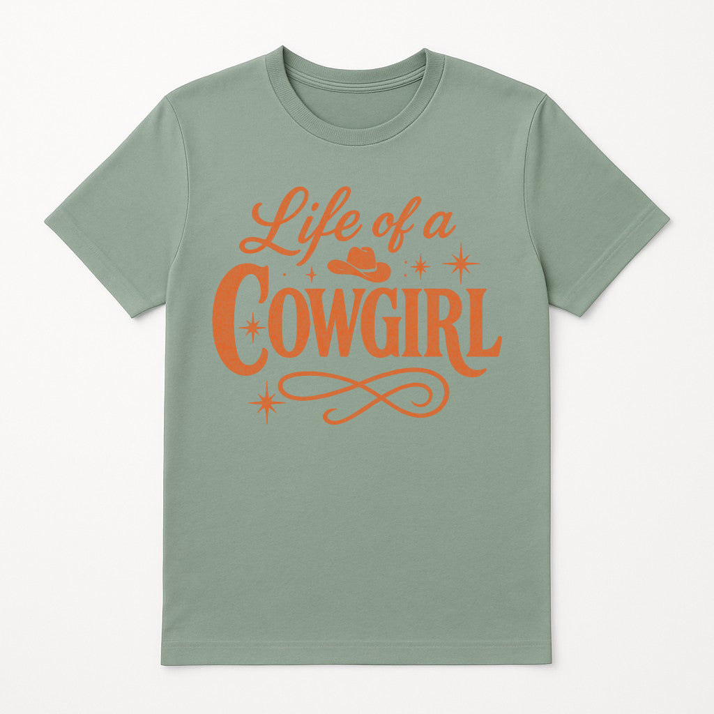 Life of a Cowgirl graphic t-shirt in sage green, retro western tee with bold orange lettering and cowboy hat design, country music inspired aesthetic shirt for women