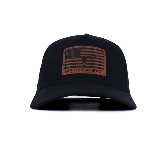 Black trucker hat with brown leather patch featuring American flag and longhorn skull by Lonestar Heritage Outpost.