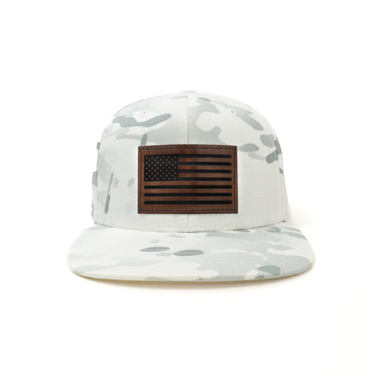 Camouflage-patterned cap with an American flag patch on a white background
