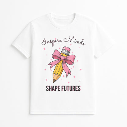 White t-shirt with a pencil and bow design and text 'Inspire Minds Shape Futures' on a white background