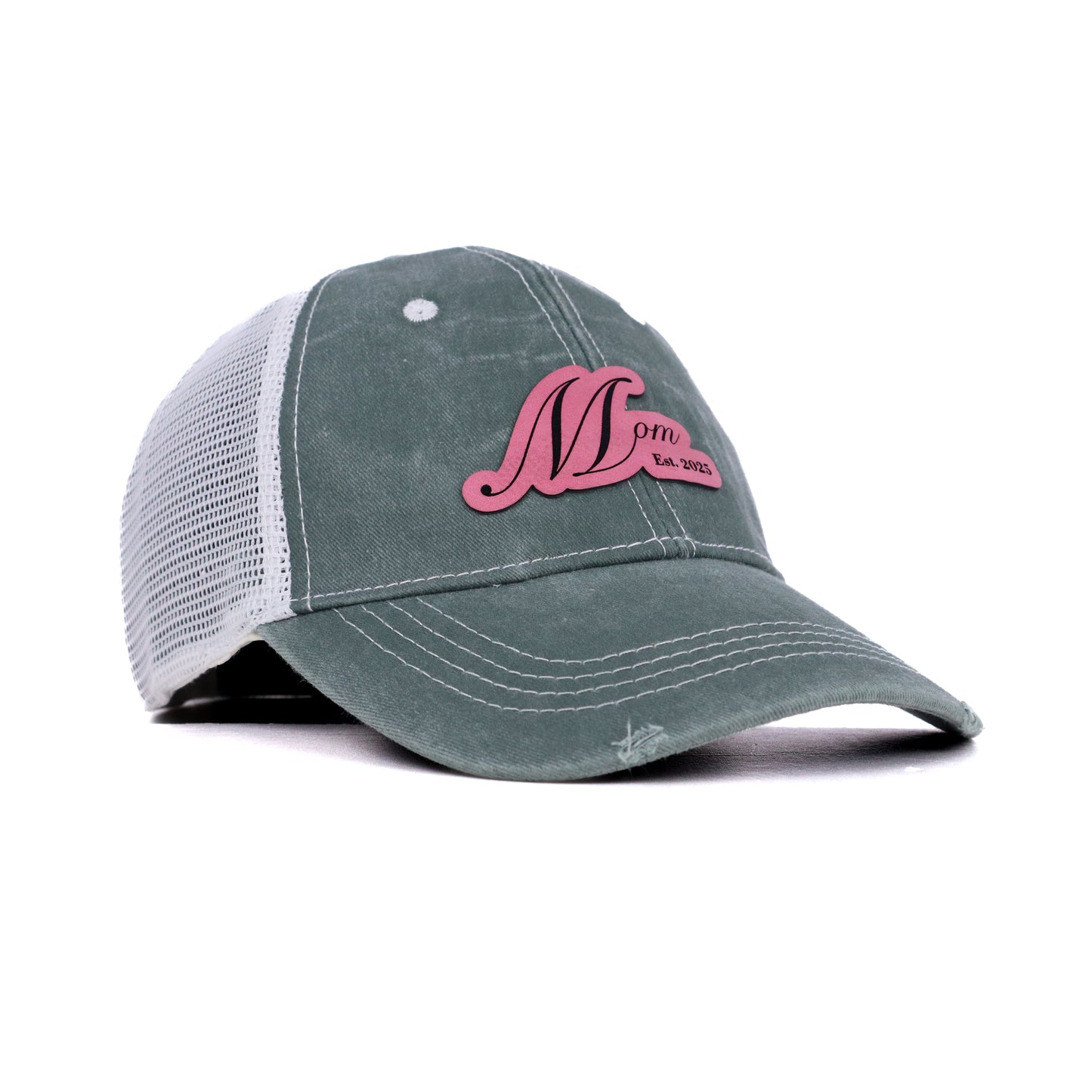 Angled front view of Mom Est. 2025 sage green trucker hat with pink leather patch