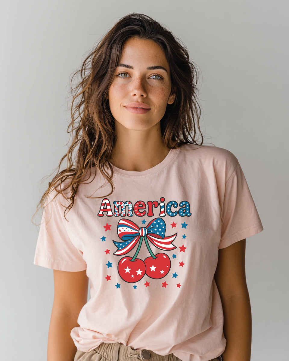 Model wearing pink America cherry graphic tee with patriotic coquette bow design