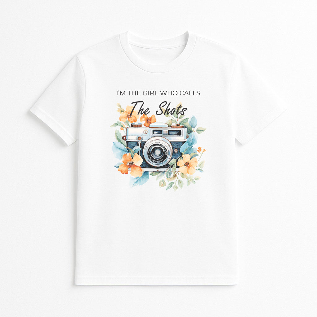 White photographer graphic t-shirt with vintage camera floral design and I’m the Girl Who Calls the Shots text