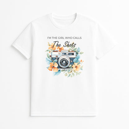 White photographer graphic t-shirt with vintage camera floral design and I’m the Girl Who Calls the Shots text