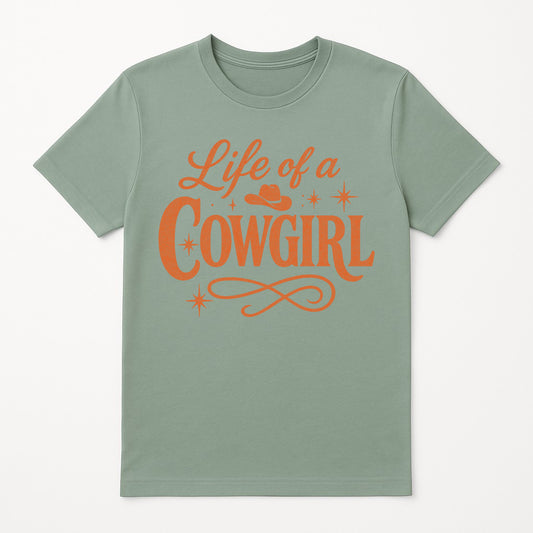 Life of a Cowgirl graphic t-shirt in sage green, retro western tee with bold orange lettering and cowboy hat design, country music inspired aesthetic shirt for women